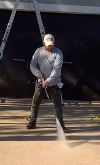 Alejandro Aguilar pressure washing a driveway