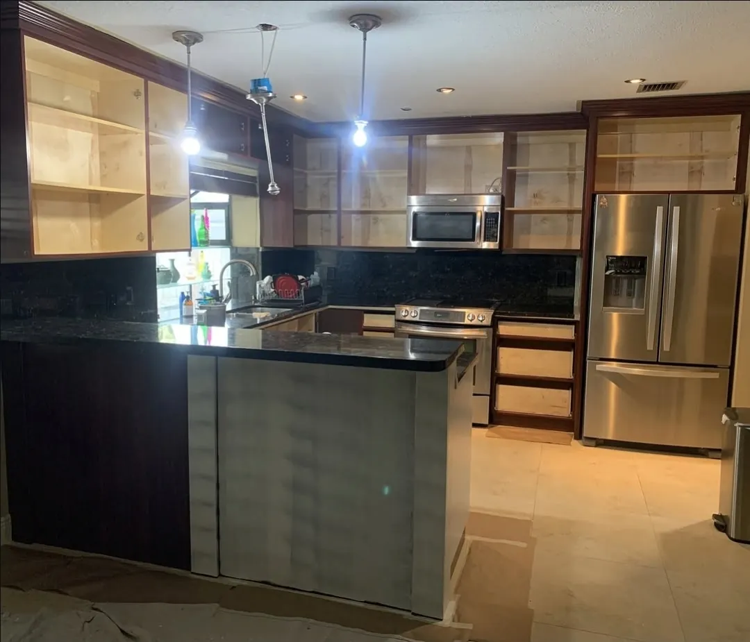 Kitchen cabinets before painting — dark wood frames with doors removed