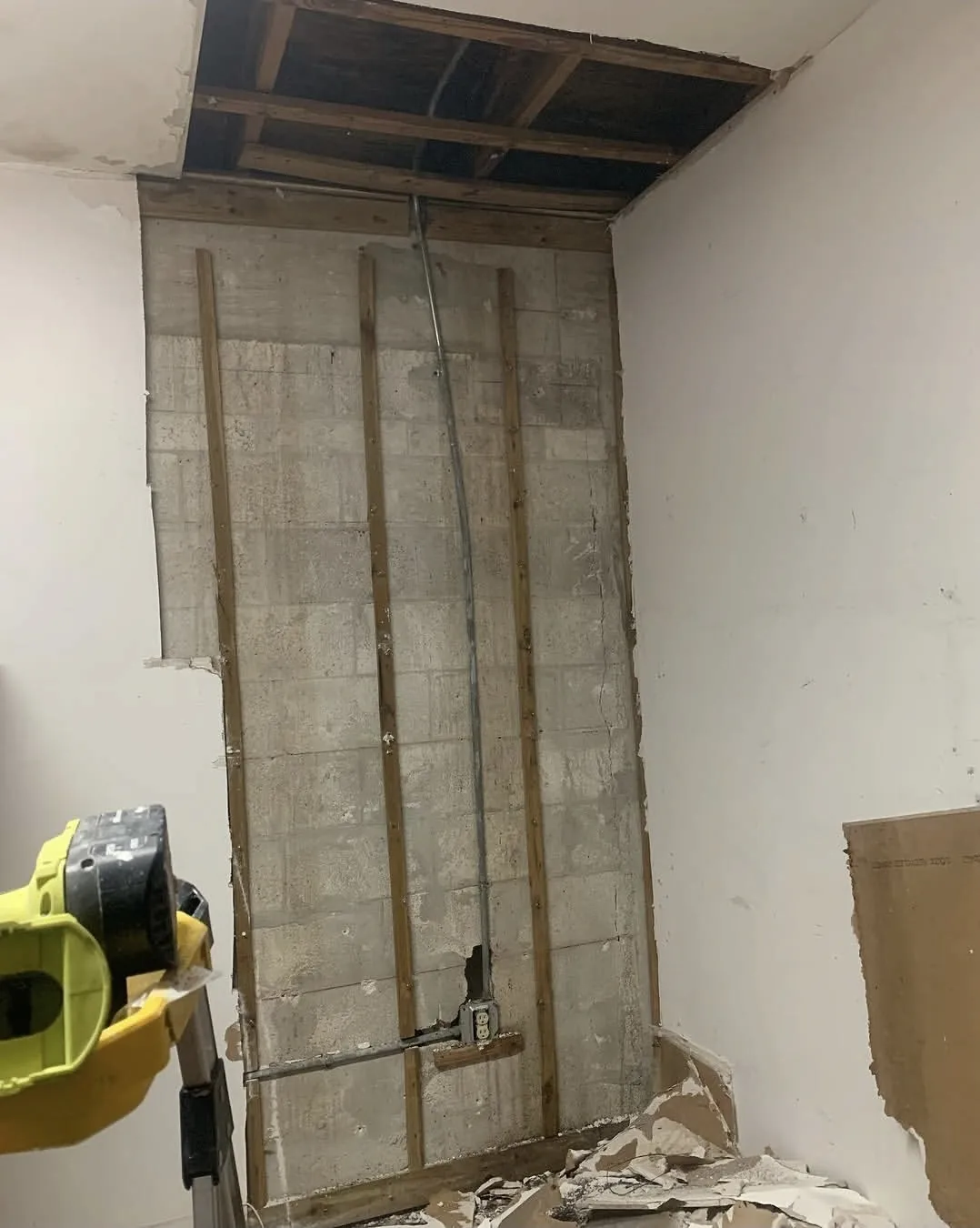 Bare concrete block wall before drywall installation