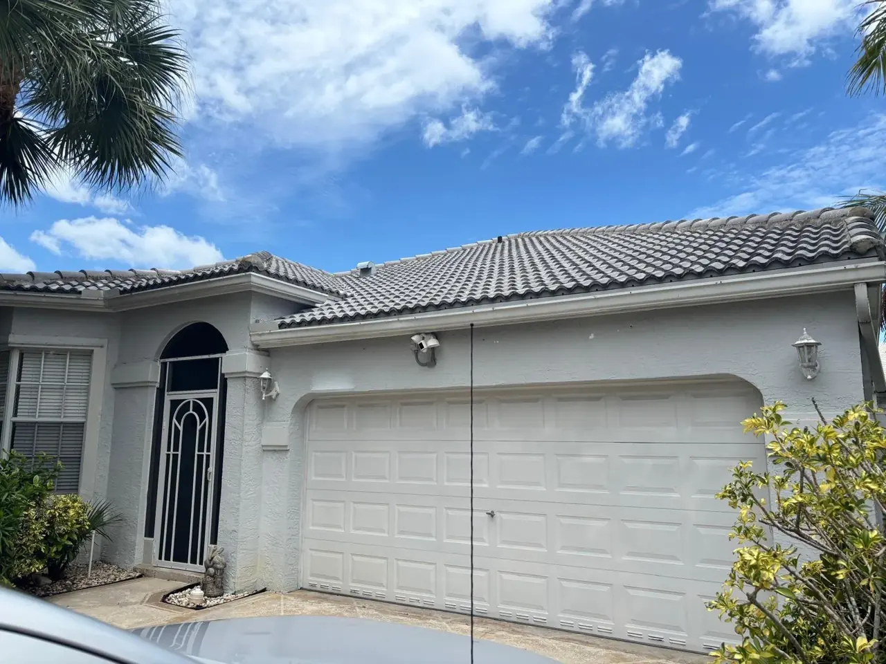 Arched entry and garage of a tile-roof South Florida home