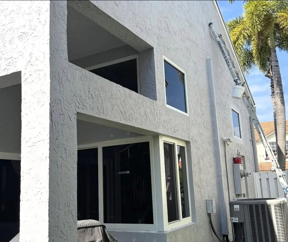 Freshly painted gray stucco exterior with palm trees