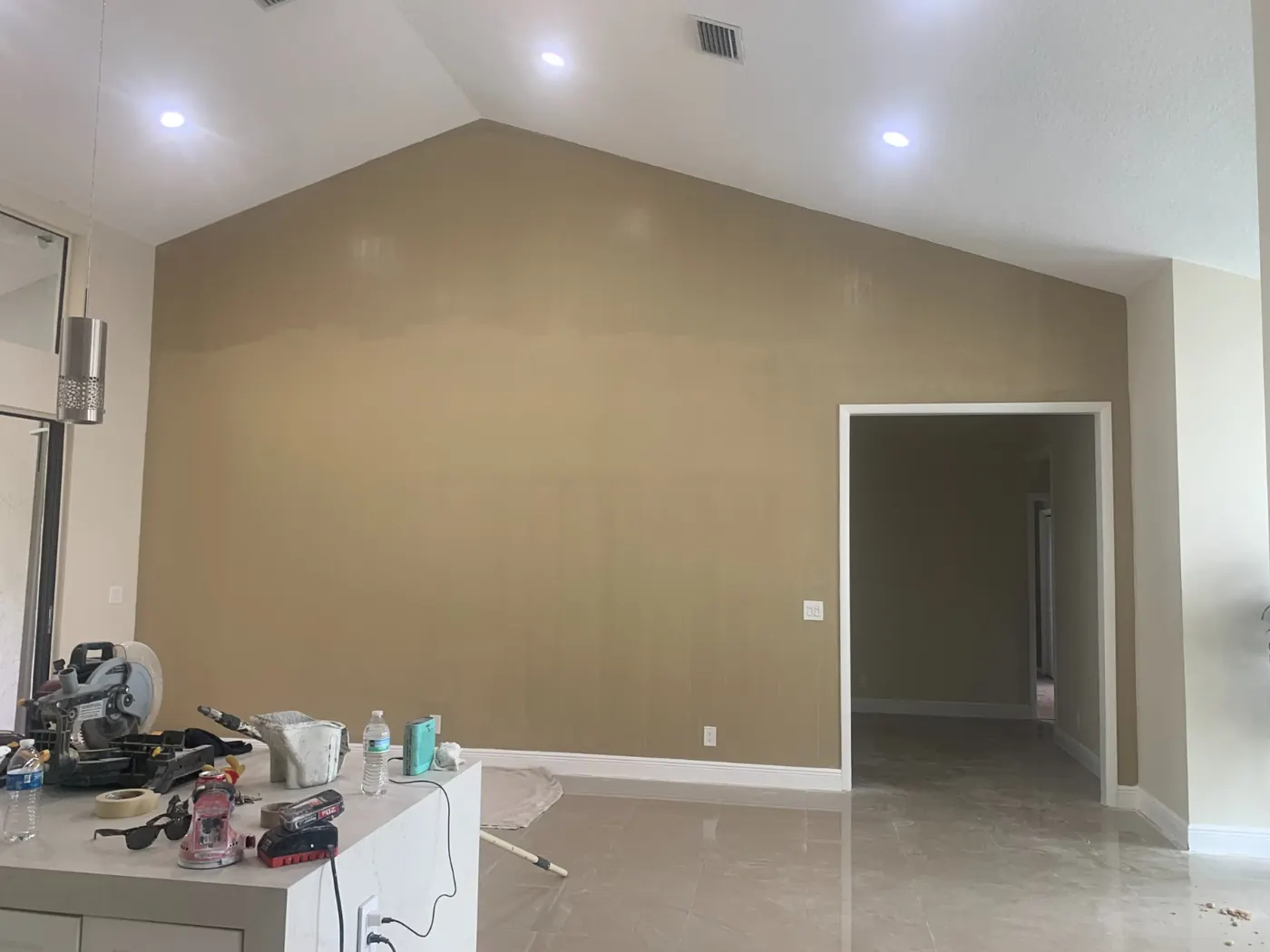 Finished tan accent wall under a vaulted ceiling