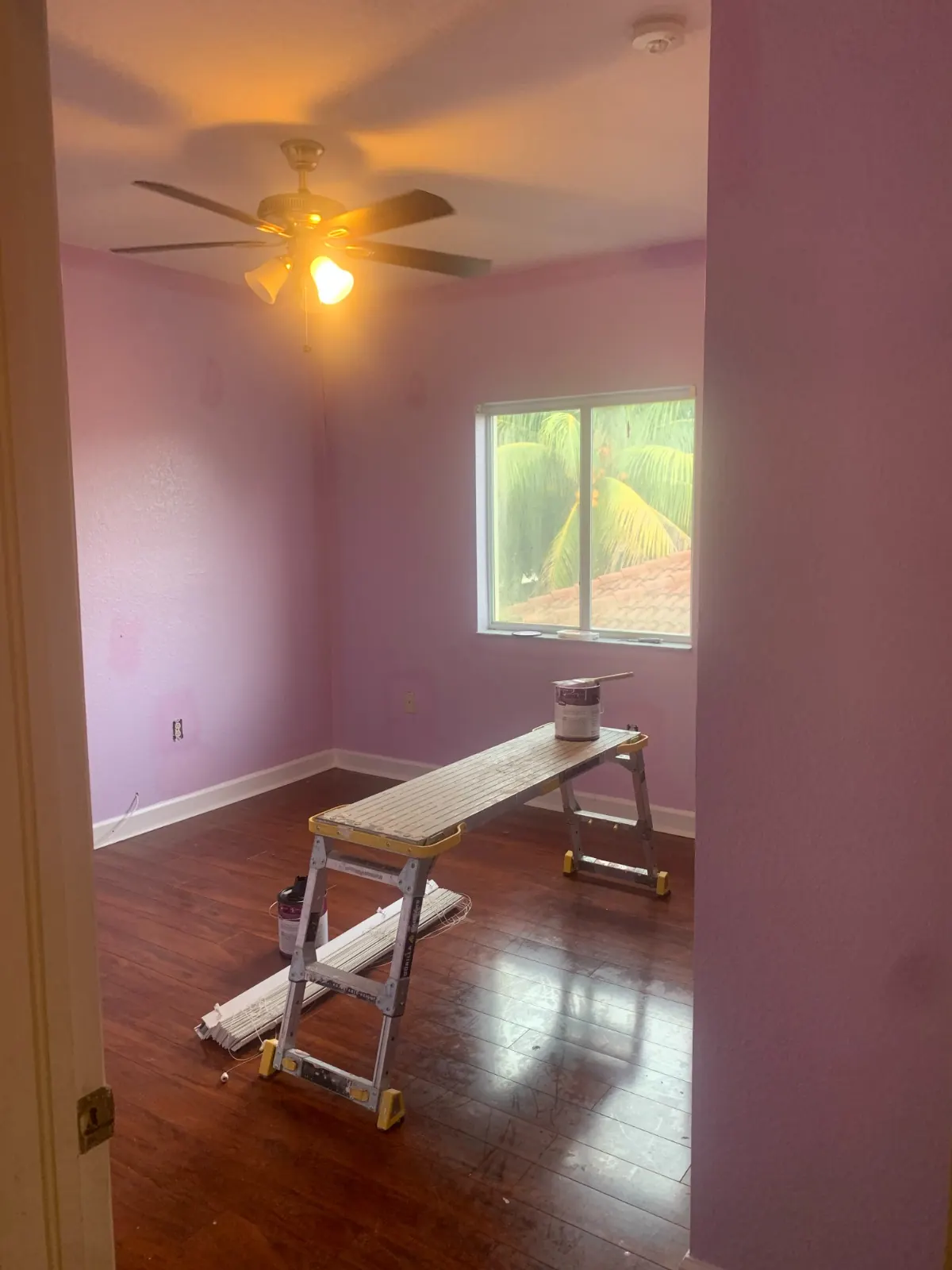 Lavender bedroom mid-job with work platform and paint