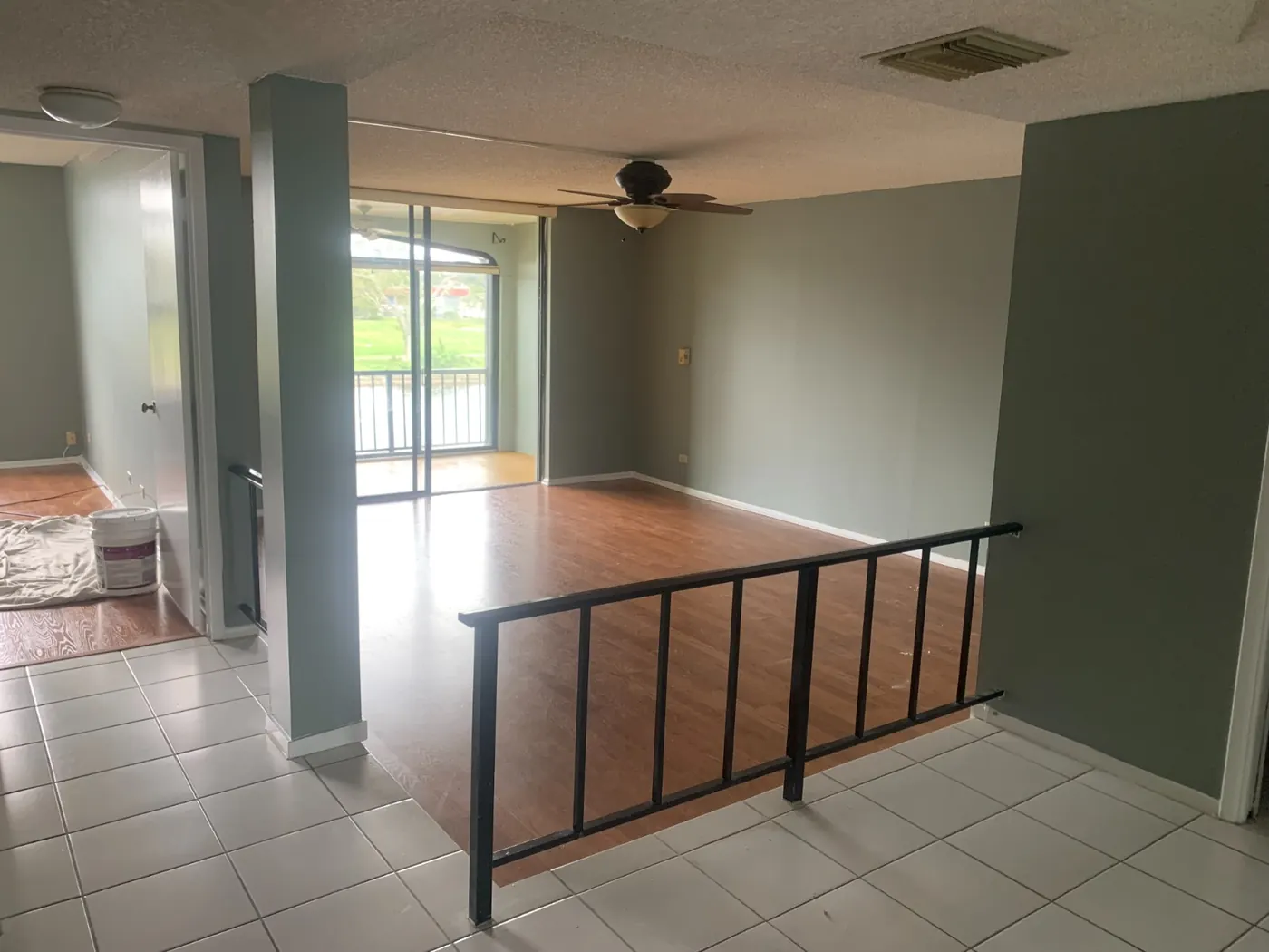 Condo living room with dated sage green walls before repainting
