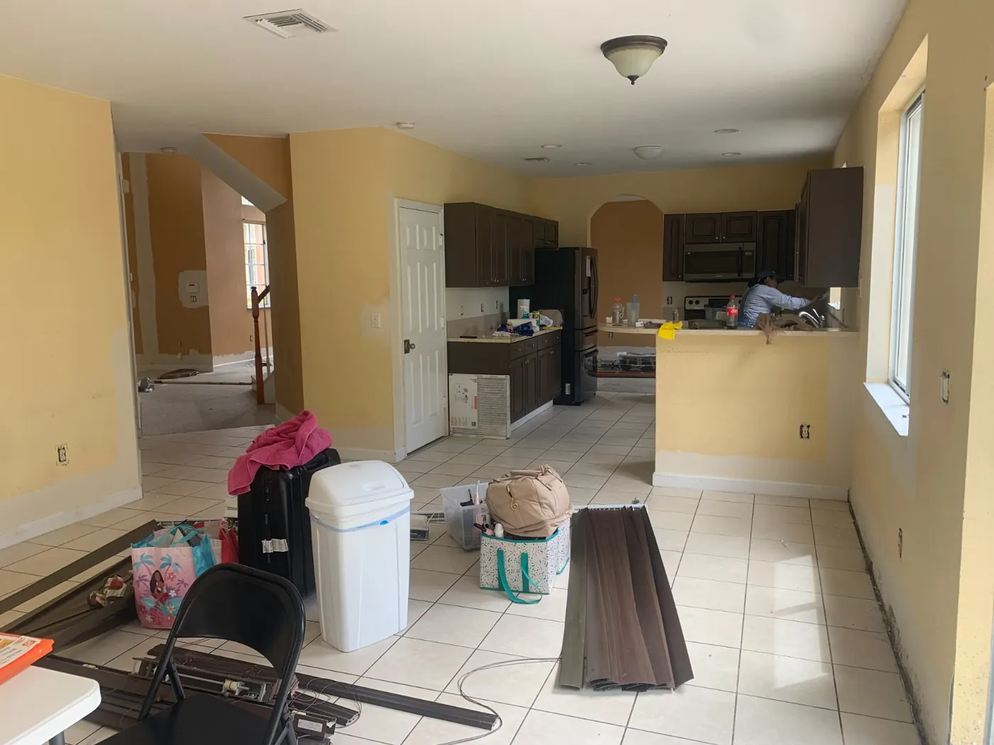 Open kitchen and living area with yellow walls before painting