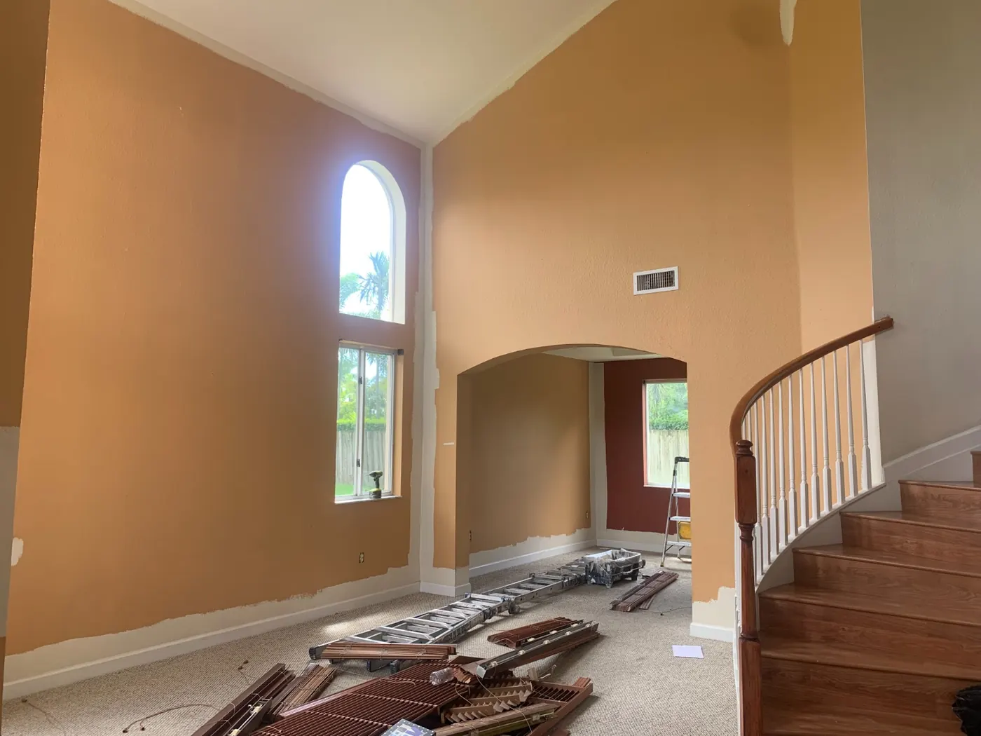 Two-story living room with orange walls before repainting