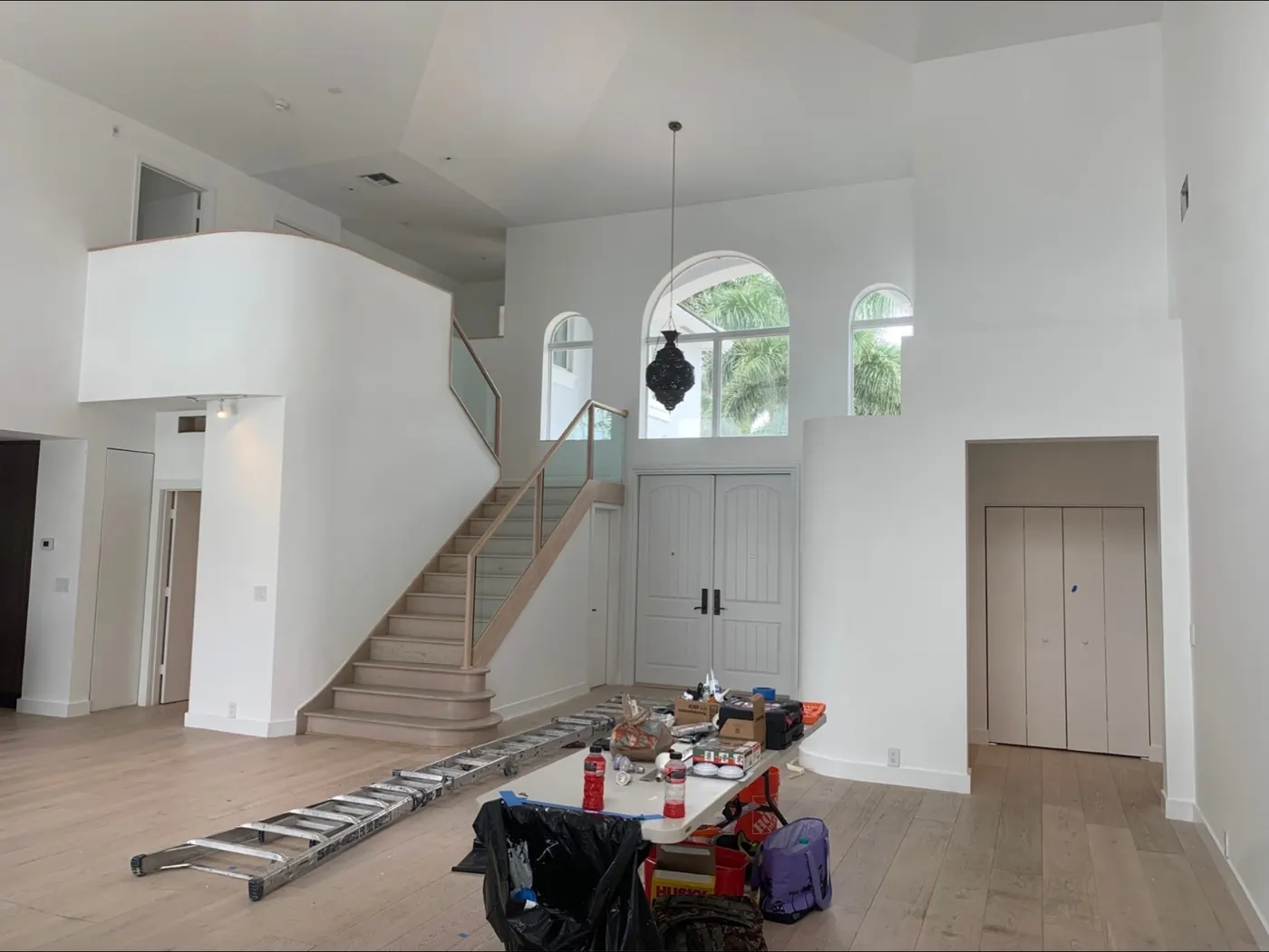 Two-story entry painted white with ladders in place
