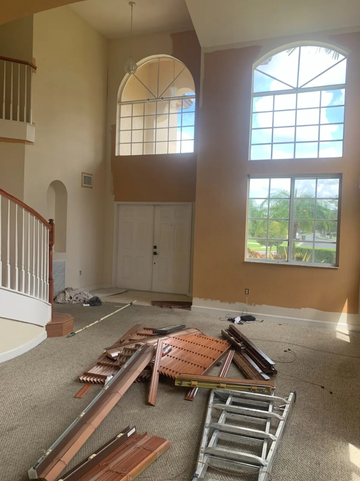 Two-story foyer with tan and orange walls before painting